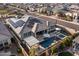 Expansive aerial view showcasing a home with a sparkling pool, spa, covered patio, solar panels and lush landscaping at 30331 N 115Th Ln, Peoria, AZ 85383