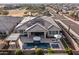 Expansive aerial view showcasing a home with a sparkling pool, spa, covered patio, solar panels and lush landscaping at 30331 N 115Th Ln, Peoria, AZ 85383