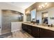 Modern bathroom featuring dual sinks, granite countertops, wood floors, and a glass-enclosed shower at 30331 N 115Th Ln, Peoria, AZ 85383