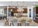 Kitchen with an oversized island with barstool seating, stylish pendant lights, and stainless steel appliances at 30331 N 115Th Ln, Peoria, AZ 85383