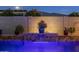 Inviting backyard pool with a water feature illuminated by blue lighting at 30331 N 115Th Ln, Peoria, AZ 85383