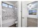 Bathroom featuring a shower-tub combo with marble surround and clear shower screen at 3419 W Thoreau Ln, Anthem, AZ 85086