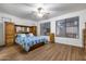 Spacious main bedroom with wood flooring, ceiling fan, and natural light from large windows at 3419 W Thoreau Ln, Anthem, AZ 85086