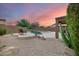 Relaxing pool with integrated spa and calming waterfall feature set against a colorful desert sunset at 3419 W Thoreau Ln, Anthem, AZ 85086