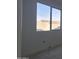 Bright window view of a neighboring roof and block wall under a clear blue sky, offering natural light at 37626 N Cowboy Ln, San Tan Valley, AZ 85140