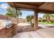 Outdoor kitchen with built-in grill overlooks a lush backyard with a sparkling pool at 3790 S Velero St, Chandler, AZ 85286