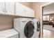 A laundry room with a large, modern washer and dryer and built-in cabinets for easy cleaning at 3790 S Velero St, Chandler, AZ 85286