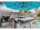 The backyard bar offers an outdoor cooking area, bar seating, and a serene view of the pool and landscaping at 3793 S Seton Ave, Gilbert, AZ 85297