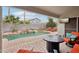 Backyard features a relaxing covered patio with seating, waterfall features, lush landscaping, and a beautiful pool at 3793 S Seton Ave, Gilbert, AZ 85297