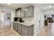 Elegant wet bar area featuring gray cabinetry, granite countertops, and an adjacent hallway at 3793 S Seton Ave, Gilbert, AZ 85297