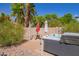 Secluded backyard with a hot tub, table and chairs, and privacy wall at 3907 N 143Rd Ln, Goodyear, AZ 85395