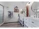 Modern bathroom featuring double sink vanities, decorative mirrors and a glass shower at 3907 N 143Rd Ln, Goodyear, AZ 85395