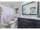 Stylishly appointed bathroom with a modern vanity and a charming lavender-themed shower curtain at 3907 N 143Rd Ln, Goodyear, AZ 85395