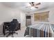 Inviting bedroom featuring a ceiling fan, work desk, and comfortable bed, creating a multi-functional space at 3907 N 143Rd Ln, Goodyear, AZ 85395