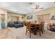 Open-concept dining room with a large wooden table and blue sofa at 3907 N 143Rd Ln, Goodyear, AZ 85395