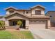 Two-story home featuring a front yard and covered porch that leads to a two car garage and desert landscaping at 3907 N 143Rd Ln, Goodyear, AZ 85395