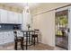 Bright eat-in kitchen featuring white cabinets, stainless steel appliances, and granite counters, leading to backyard at 3907 N 143Rd Ln, Goodyear, AZ 85395