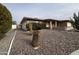 Inviting single-story home featuring easy desert rock landscaping, flowers, and charming cactus at 4026 E Catalina Cir, Mesa, AZ 85206