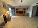 Spacious living room with tile floors, fan, built in shelving, and access to front door at 4026 E Catalina Cir, Mesa, AZ 85206