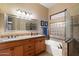 Bathroom featuring double sinks, granite counters, soaking tub and glass-enclosed shower at 4317 E Williams Dr, Phoenix, AZ 85050