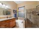 Modern bathroom with double sinks, granite counters, soaking tub and glass-enclosed shower at 4317 E Williams Dr, Phoenix, AZ 85050