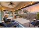 Covered patio with ceiling fan, string lights, and furniture overlooking pool at dusk at 4317 E Williams Dr, Phoenix, AZ 85050