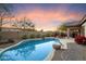 Relaxing backyard pool with well manicured landscaping, including the desert landscaping and school in the background at 4317 E Williams Dr, Phoenix, AZ 85050