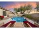 Backyard pool with lounge chairs and lush landscaping at sunset at 4317 E Williams Dr, Phoenix, AZ 85050