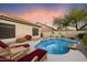 Backyard pool with lounge chairs and lush landscaping at dusk at 4317 E Williams Dr, Phoenix, AZ 85050