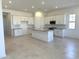 Bright, open-concept kitchen features white cabinets, a center island and modern appliances at 43527 N Wollemi St, Queen Creek, AZ 85140
