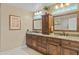 Dual sink bathroom with wood cabinets, granite countertop, and decorative mirrors at 4534 E Oberlin Way, Cave Creek, AZ 85331