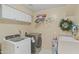 Laundry room with front loading washer and dryer, storage cabinets, and utility sink at 4534 E Oberlin Way, Cave Creek, AZ 85331