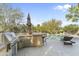 Outdoor kitchen with a built in grill, bar seating, and a view of the pool at 4534 E Oberlin Way, Cave Creek, AZ 85331