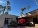 A building with a red bush and palm trees on a sunny day with a clear blue sky at 5124 N 31St Pl # 542, Phoenix, AZ 85016