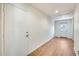 Hallway with wood floors, white walls, and doors at both ends at 5513 W Tierra Buena Ln, Glendale, AZ 85306