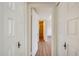 Hallway with wood-look flooring and white paneled doors looking into a bedroom at 5513 W Tierra Buena Ln, Glendale, AZ 85306