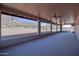 The covered patio has mountain views, grey floors, ceiling fans, and block fencing at 5962 E Siesta St, Apache Junction, AZ 85119