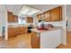 Well-lit kitchen with wooden cabinets, breakfast bar, tile floors, and stainless steel appliances at 5962 E Siesta St, Apache Junction, AZ 85119