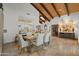 Bright dining room featuring travertine floors, wooden-beam ceilings, skylight, and an open view to the kitchen at 6188 N 29Th Pl, Phoenix, AZ 85016