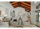 Open-concept living room showcasing travertine floors, wood beam ceilings, and dining and kitchen views at 6188 N 29Th Pl, Phoenix, AZ 85016