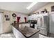 Well-lit kitchen offering a breakfast bar, stainless steel refrigerator, and white cabinetry at 6335 E Brown Rd # 1081, Mesa, AZ 85205