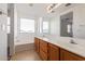 Bright bathroom featuring a double sink vanity, large mirror, and soaking tub beneath a window at 6350 W Hess St, Phoenix, AZ 85043