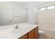 Bright bathroom featuring a large mirror, white tile shower-tub and modern vanity at 6350 W Hess St, Phoenix, AZ 85043