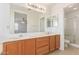 Primary bath features a double sink vanity with wood cabinets, an oversized mirror and walk in shower at 6350 W Hess St, Phoenix, AZ 85043