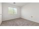 Bright bedroom with a window overlooking trees, neutral carpeting and white walls at 6350 W Hess St, Phoenix, AZ 85043