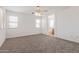 Spacious bedroom featuring plush carpet, a ceiling fan, natural light, and ensuite bathroom access at 6350 W Hess St, Phoenix, AZ 85043