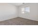 Bedroom with a large window, carpeted floor, and white walls, creating a bright, blank space at 6350 W Hess St, Phoenix, AZ 85043