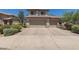 Two-story tan home with a three car garage and desert landscaping at 6350 W Hess St, Phoenix, AZ 85043