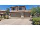 Three car garage in a two-story tan home with a tile roof at 6350 W Hess St, Phoenix, AZ 85043