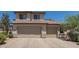 Three car garage in a two-story tan home with a tile roof at 6350 W Hess St, Phoenix, AZ 85043